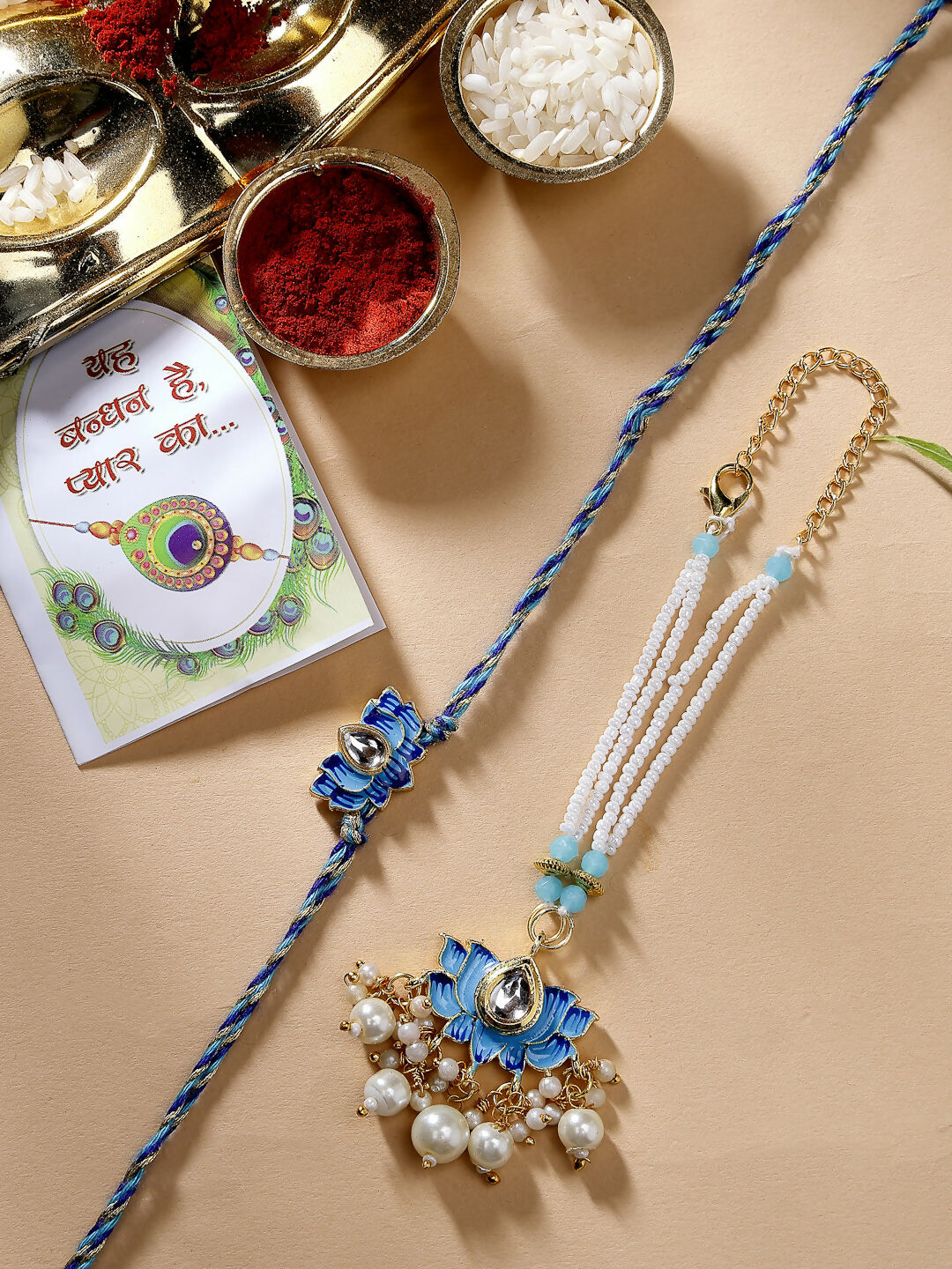 NVR Women & Men Set of 2 Blue Lotus Shape Kundan-Studded & Beaded Wraparound Rakhi Set With Roli Chawal & Chocolate - Distacart