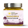 A jar of Kerala Ayurveda Narasimha Rasayanam, with a label featuring a illustration of a person and trees, indicating it is a herbal supplements product.